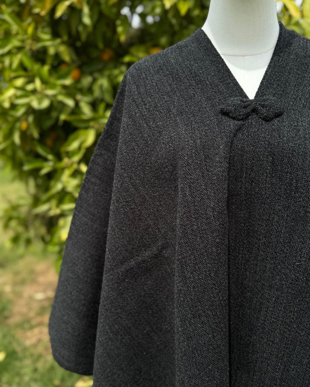 Detalle del cuello en V de la Manta Lisa Gris Marengo repelente al agua.