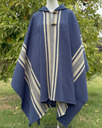 Poncho Coihue azul con franjas beige, capucha y botones frontales.