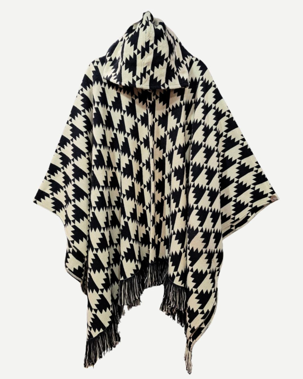 Poncho Trekan negro y crudo completo con capucha, flecos y diseño artesanal.