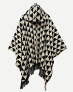 Poncho Trekan negro y crudo completo con capucha, flecos y diseño artesanal.