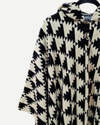 Detalle del tejido geométrico negro y crudo del Poncho Trekan de alpaca y algodón.