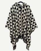 Poncho Trekan negro y crudo de alpaca y algodón con capucha y diseño geométrico frontal.