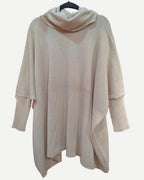 Vista frontal del Sweater Poncho Austral beige de algodón con cuello tortuga y mangas.